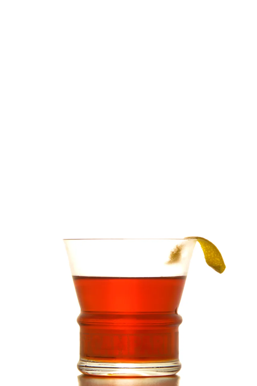 Negroni servido em copo baixo com uma casca de cítrico